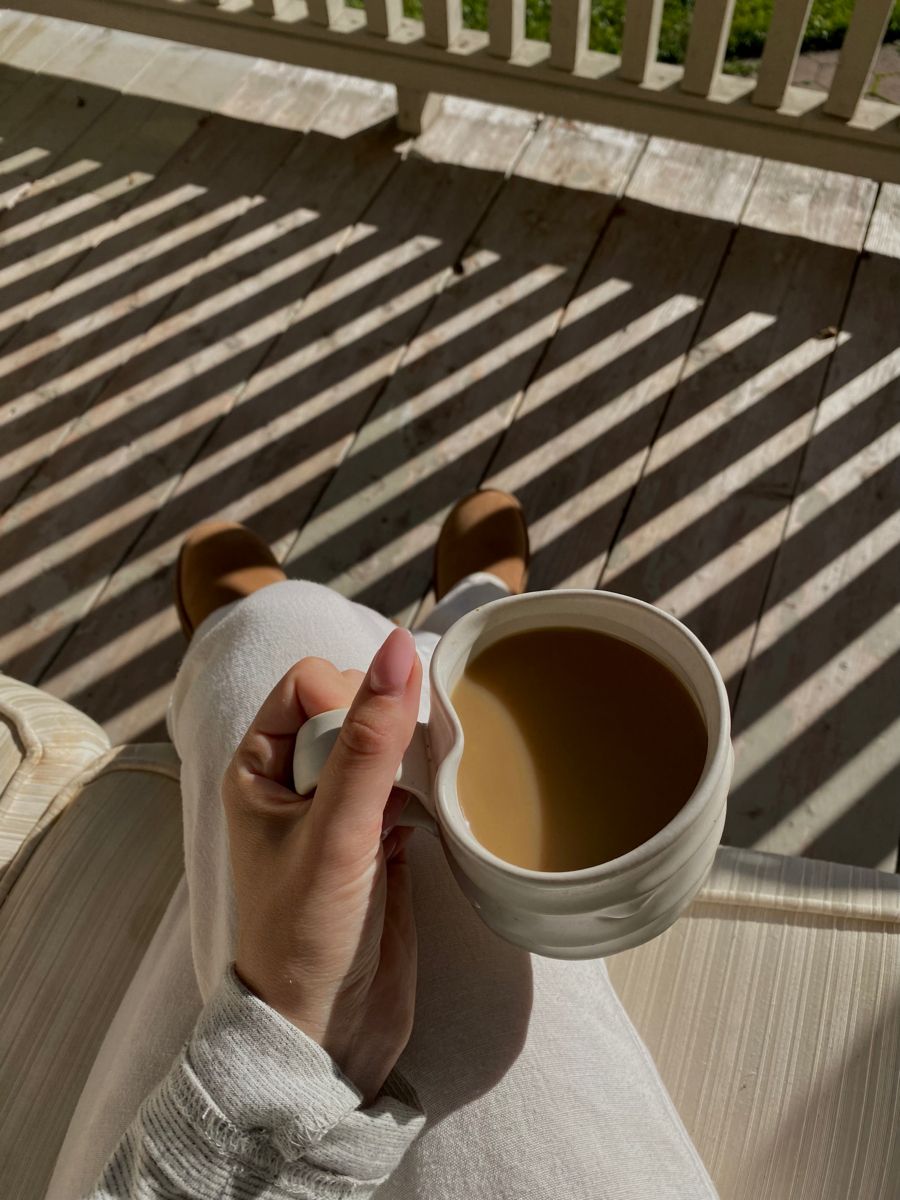 Sitting quietly on a sunlit porch with a mug
